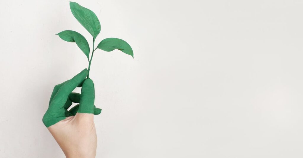 A hand painted green holds a fresh plant sprout against a light background, symbolizing growth and sustainability.